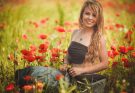 pretty smiling young woman in field of flowers